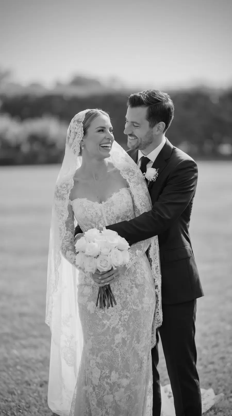 Wedding day couple portrait — fitted lace mermaid silhouette, groom with his arm around the bride