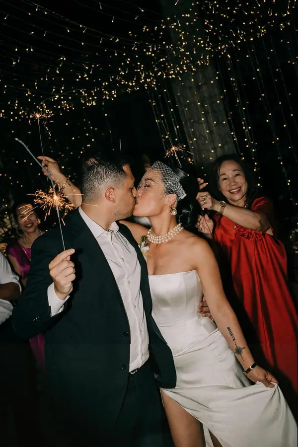 Celebration moment — bride and groom with sparklers, wedding party, custom VI Dressmakers ivory satin gown