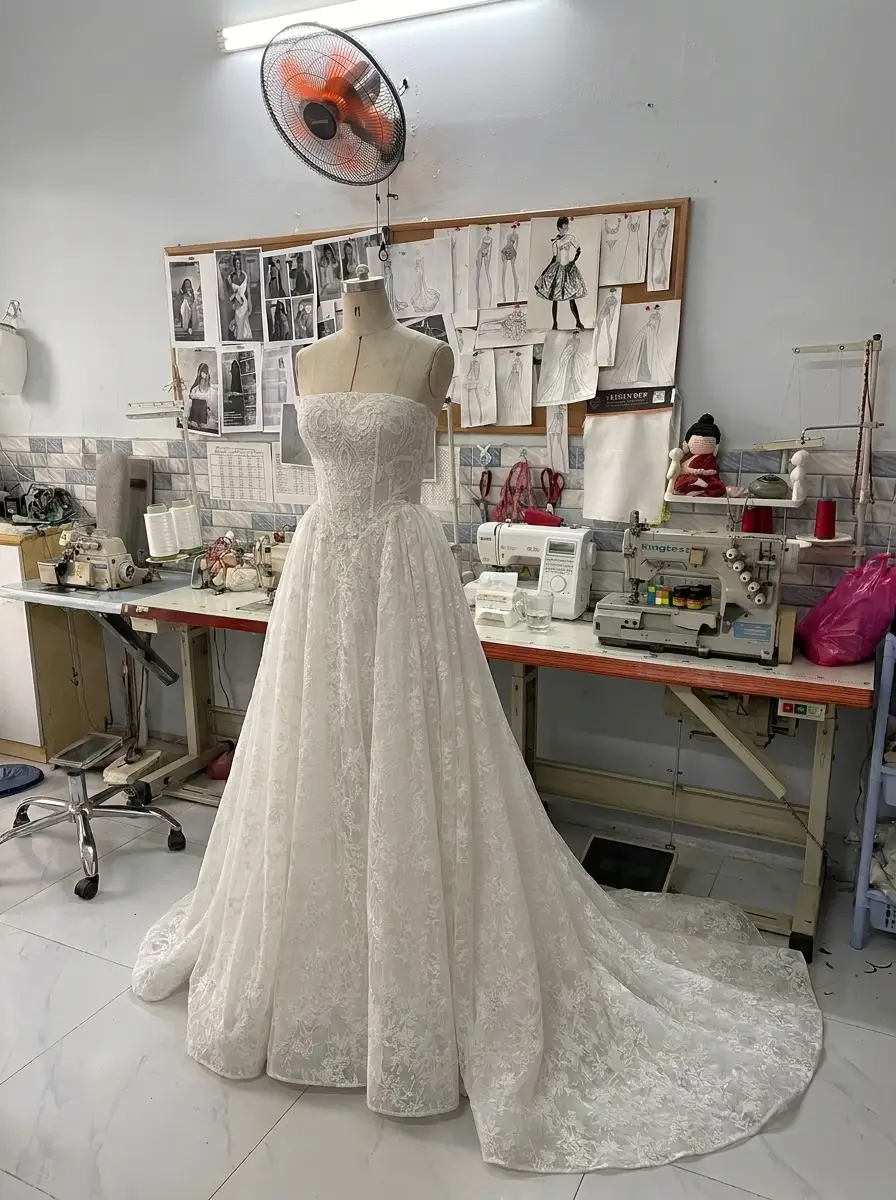 Production-house photo showing an A-line wedding dress silhouette with a fitted bodice and softly widening skirt