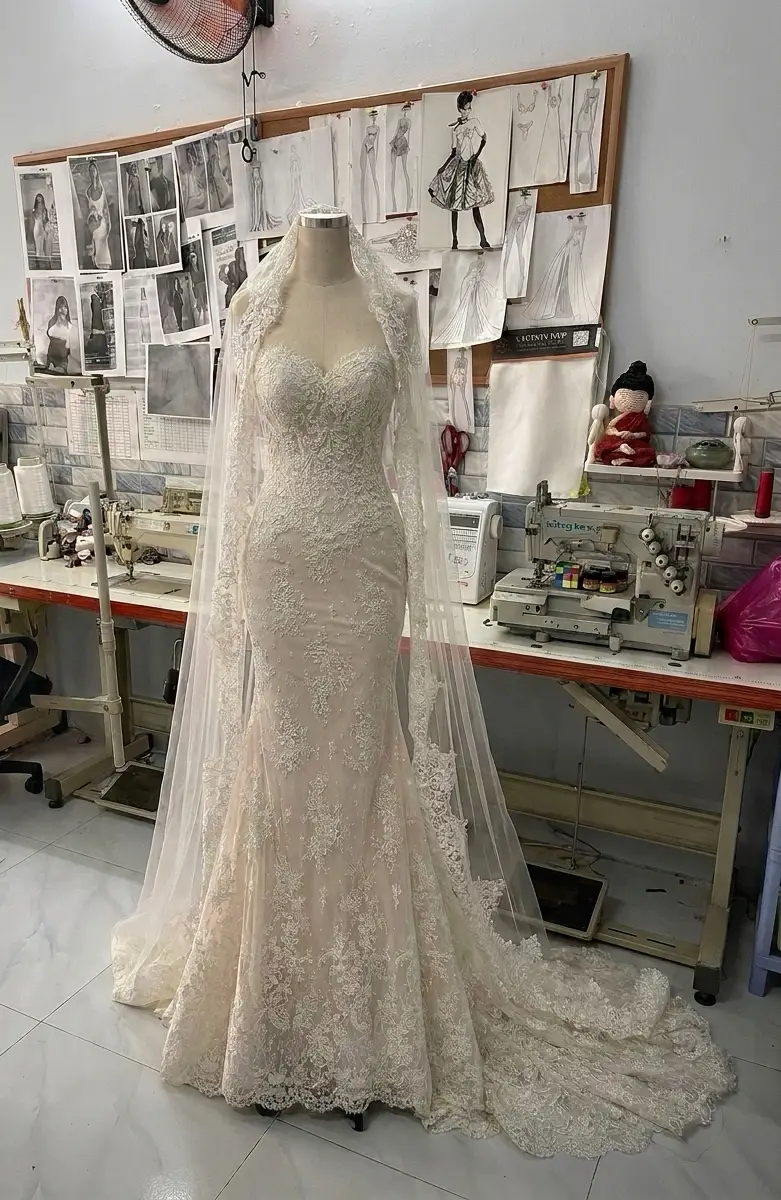 Production-house photo showing a mermaid wedding dress silhouette fitted through the hip and thigh with flare below the knee